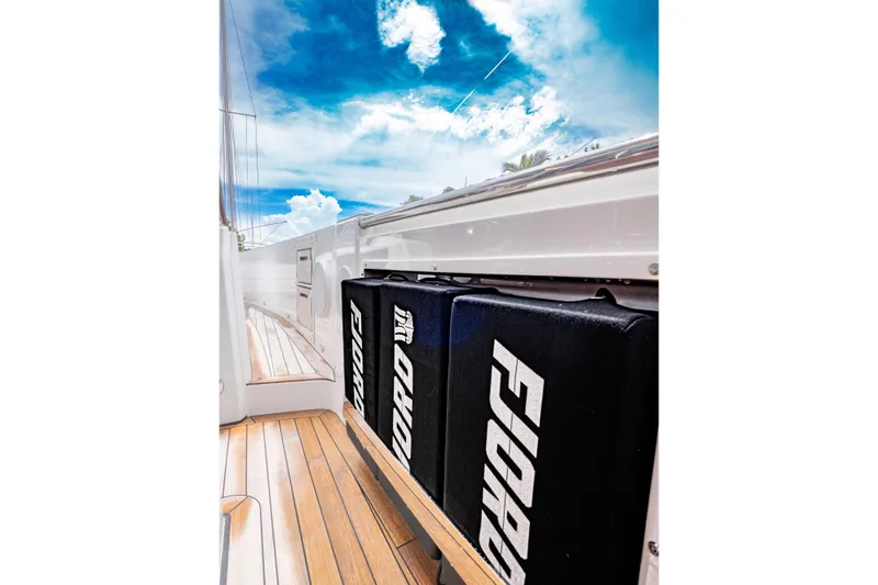 Slide: The Image of 2024 Fjord 41 XP yacht deck with branded cushions under a vibrant sky. - 15