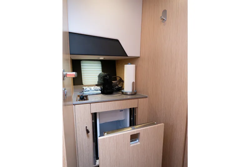 Slide: The Image of 2024 Fjord 41 XP yacht interior kitchenette with modern appliances and wooden cabinetry. - 20