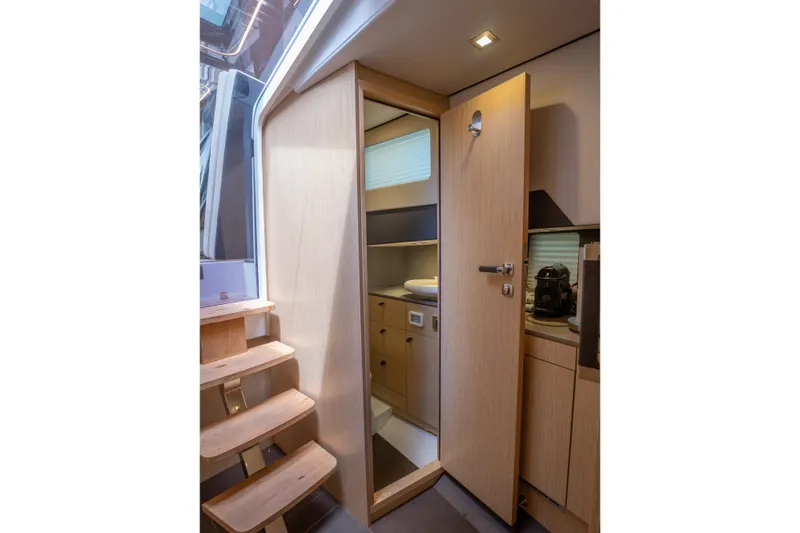 Slide: The Image of Interior of 2024 Fjord 41 XP yacht, featuring wooden stairs and modern cabinetry. - 22