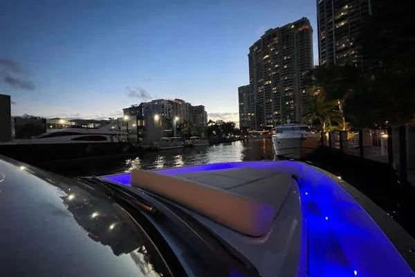 Slide: The Image of 2024 Fjord 41 XP yacht with blue LED lights docked at night in urban marina. - 40