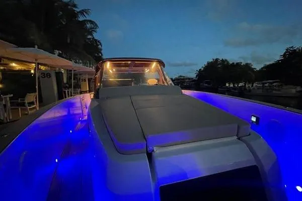 Slide: The Image of 2024 Fjord 41 XP yacht with blue LED lights at night, docked near palm trees. - 41