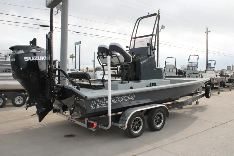 Slide: The Image of 2026 Freedom Boats 24 Defender on trailer, featuring Suzuki outboard motor. - 14