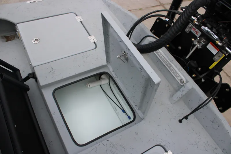 Slide: The Image of 2026 Freedom Boats 24 Defender with open storage compartment and visible engine components. - 16