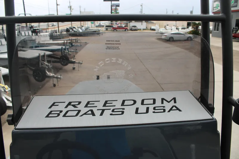 Slide: The Image of 2026 Freedom Boats 24 Defender with "Freedom Boats USA" branding at a dealership. - 19