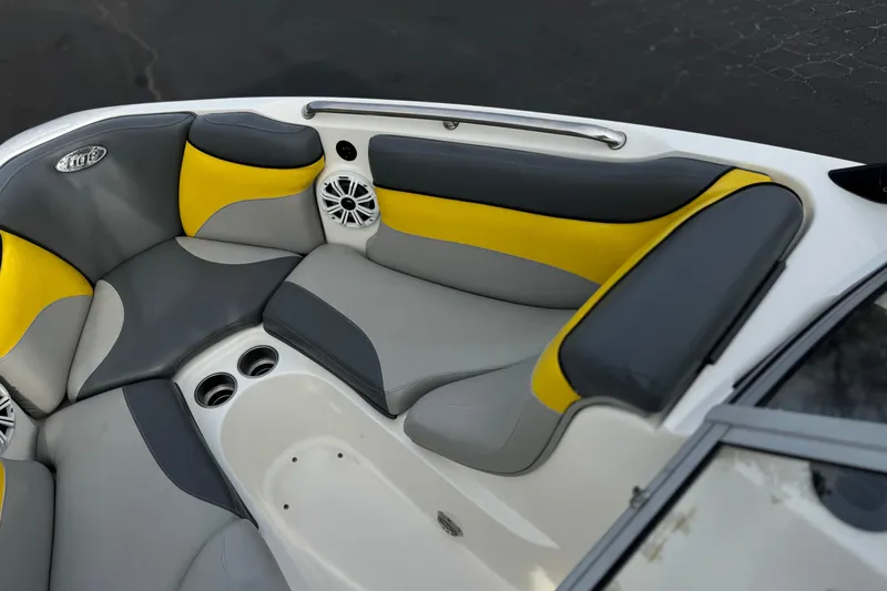 Slide: The Image of 2006 Tigé 22V boat interior with gray and yellow seating, featuring cup holders and speakers. - 13