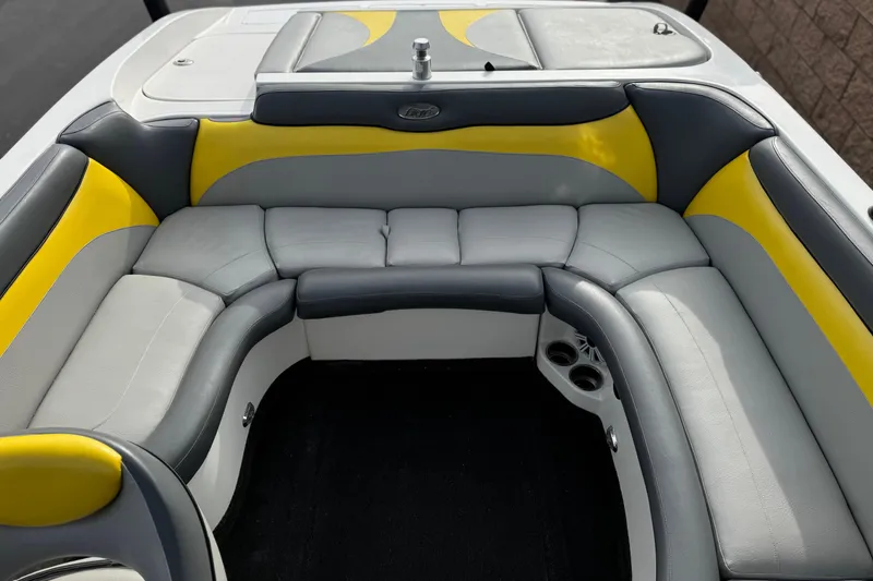 Slide: The Image of 2006 Tigé 22V boat interior with gray and yellow seating, featuring cup holders. - 19