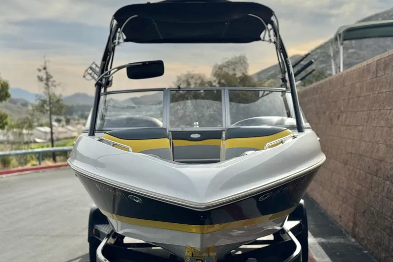 Slide: The Image of 2006 Tigé 22V boat with sleek design, parked outdoors on a sunny day. - 2