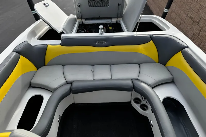 Slide: The Image of 2006 Tigé 22V boat interior with gray and yellow seating, open storage compartments. - 20