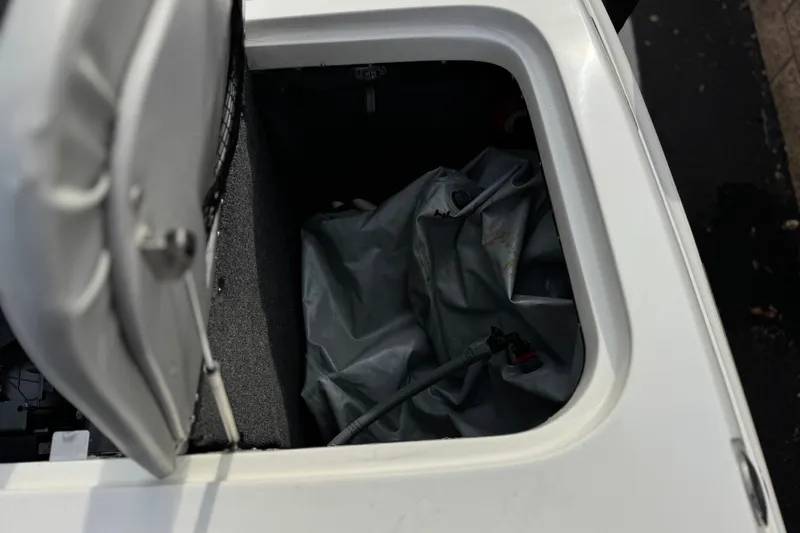 Slide: The Image of Open storage compartment in a 2006 Tigé 22V boat, showing interior details. - 22