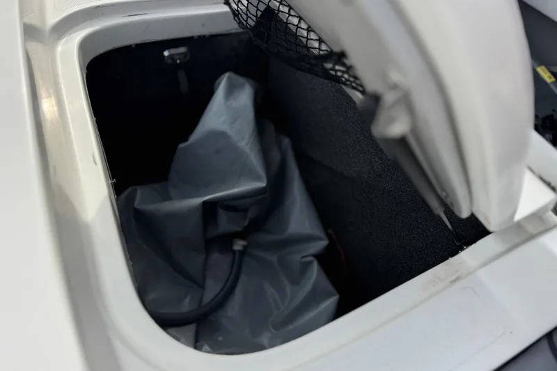 Slide: The Image of Storage compartment of a 2006 Tigé 22V boat with a gray cover inside. - 23