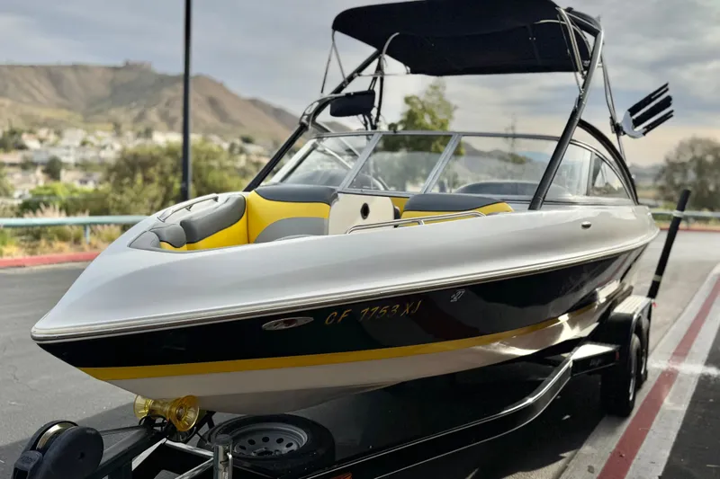 Slide: The Image of 2006 Tigé 22V boat on trailer, featuring sleek design and vibrant yellow interior accents. - 3