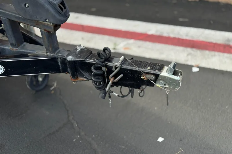 Slide: The Image of Trailer hitch of a 2006 Tigé 22V boat on asphalt pavement. - 34
