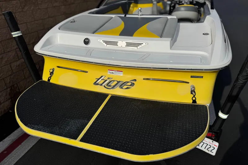 Slide: The Image of 2006 Tigé 22V boat, yellow and white, rear view with swim platform. - 6
