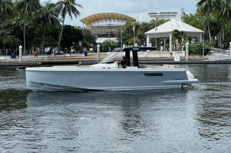 The Image of 2023 Fjord 38 Xpress boat cruising on a calm waterway near a park. - 1
