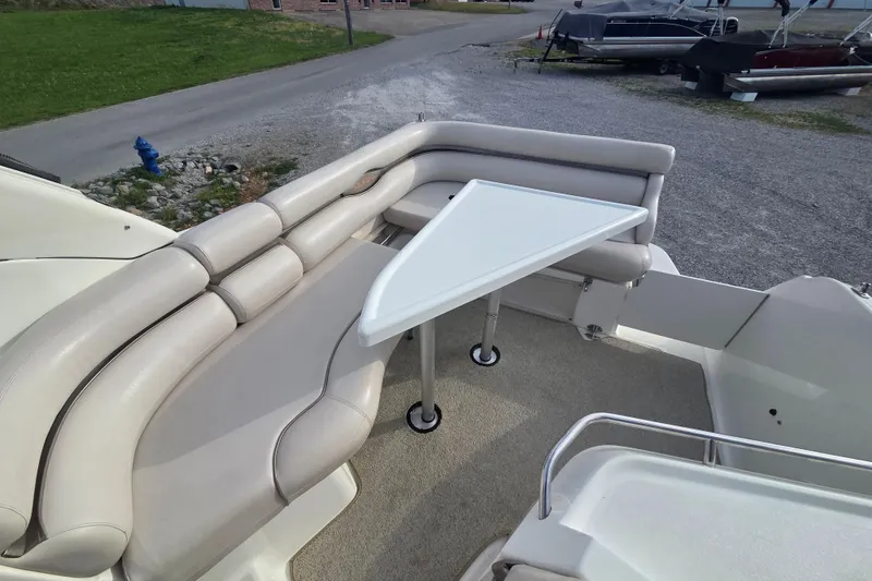 Slide: The Image of 2001 Doral 270 SC boat interior with beige seating and a triangular table. - 10