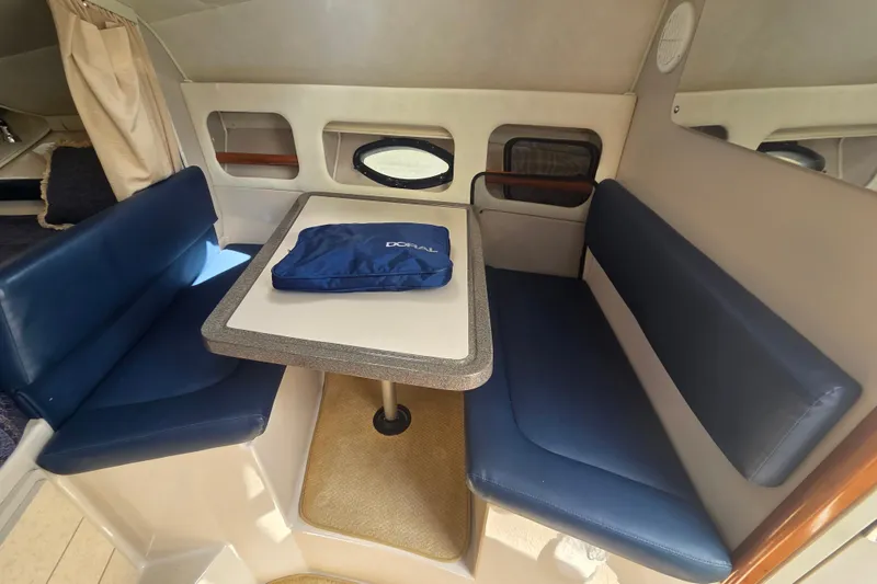 Slide: The Image of Interior of 2001 Doral 270 SC boat with blue seating and table. - 15
