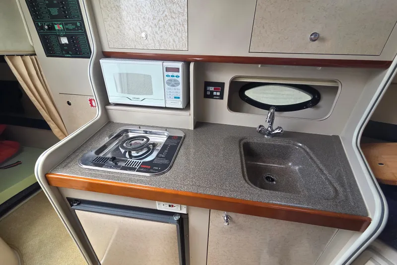Slide: The Image of 2001 Doral 270 SC boat kitchenette with stove, microwave, sink, and compact design. - 17