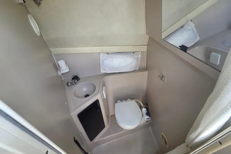 Slide: The Image of 2001 Doral 270 SC boat bathroom with sink, toilet, and mirror. - 19