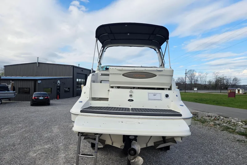 Slide: The Image of 2001 Doral 270 SC boat with canopy, parked outdoors near a building. - 3