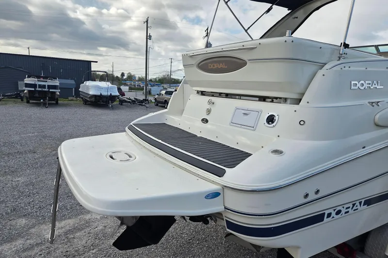 Slide: The Image of 2001 Doral 270 SC boat rear view, parked outdoors on gravel lot. - 4