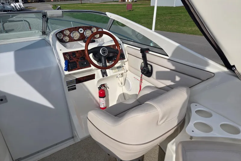 Slide: The Image of 2001 Doral 270 SC boat cockpit with steering wheel, gauges, and beige seating. - 5