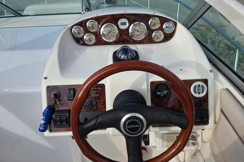 Slide: The Image of Steering console of a 2001 Doral 270 SC boat with wood accents and gauges. - 6
