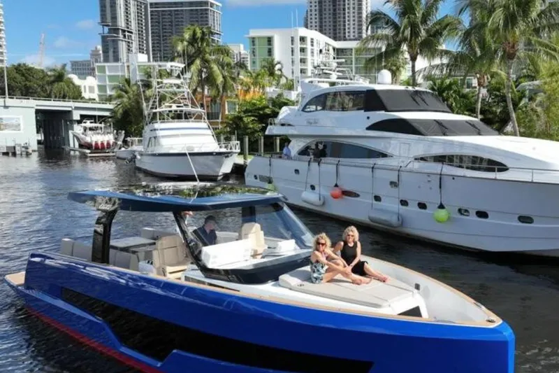 Slide: The Image of 2023 Fjord 41 XL yacht cruising in a marina with palm trees and skyscrapers. - 4