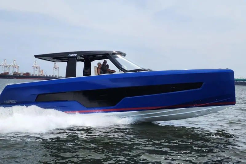 Slide: The Image of 2023 Fjord 41 XL boat cruising on water, showcasing sleek blue design. - 5