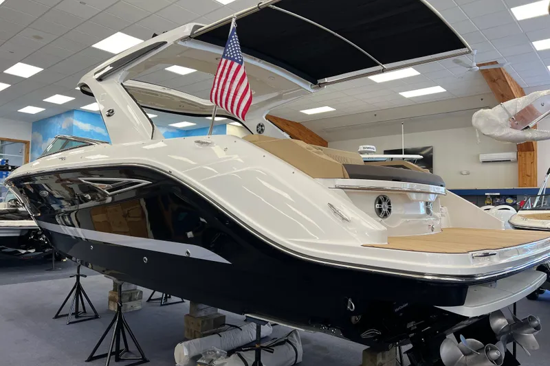 Slide: The Image of 2024 Sea Ray SLX 310 boat displayed indoors with American flag. - 2