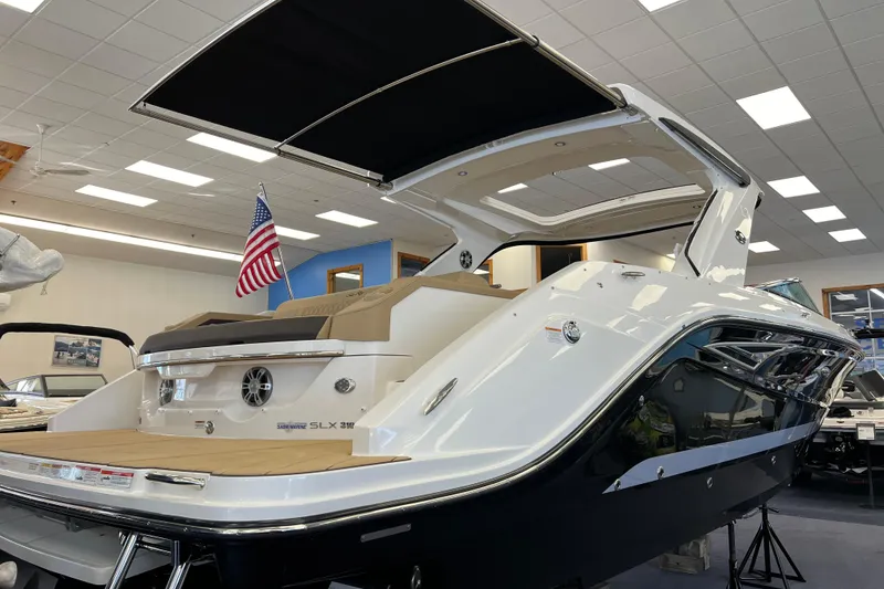 Slide: The Image of 2024 Sea Ray SLX 310 boat displayed indoors with American flag. - 3