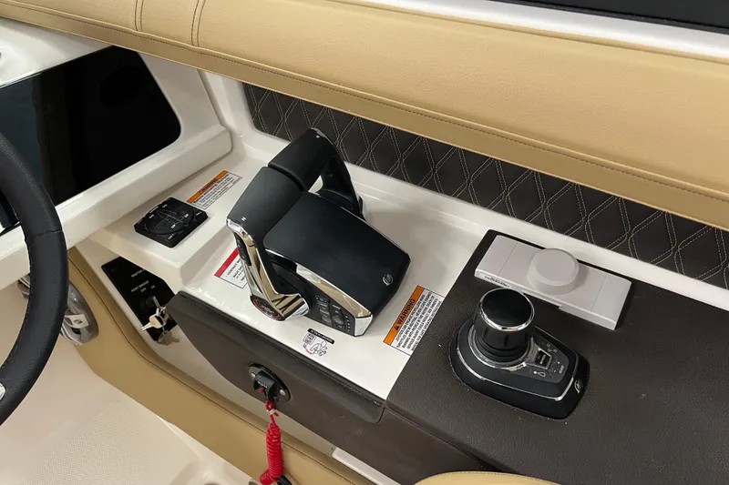 Slide: The Image of 2024 Sea Ray SLX 310 helm controls with joystick and throttle levers. - 35