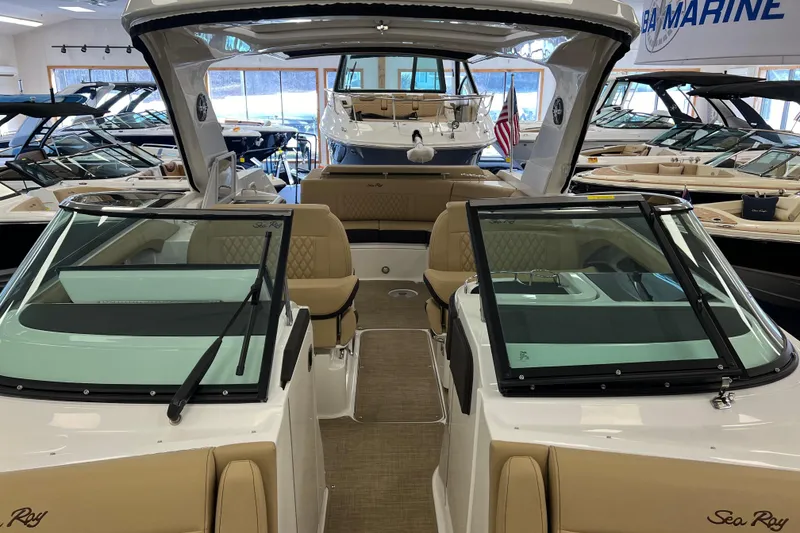 Slide: The Image of 2024 Sea Ray SLX 310 luxury boat interior with tan seating, showcased in a marine showroom. - 43