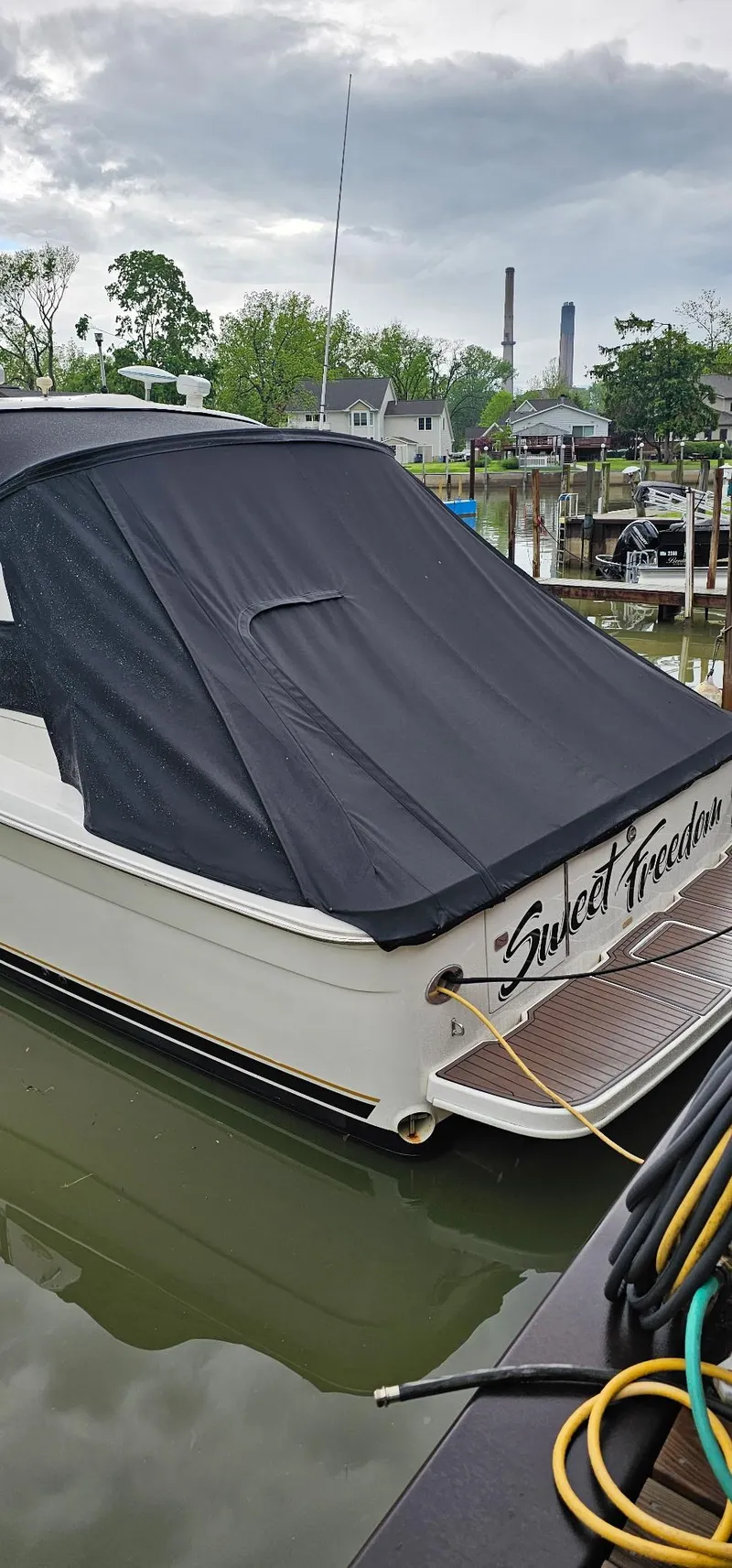 Slide: The Image of 1997 Sea Ray 330 Express docked, covered, with "Sweet Freedom" on the stern. - 45