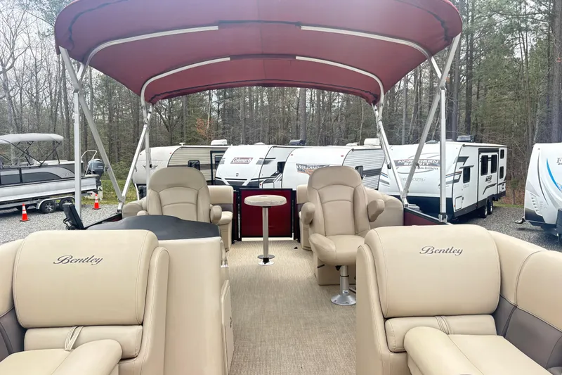 Slide: The Image of 2022 Bentley Pontoons 220 Navigator with beige seating and red canopy, parked near RVs. - 4