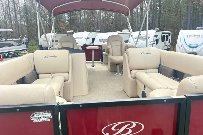 Slide: The Image of 2022 Bentley Pontoons 220 Navigator with luxurious seating and canopy in a wooded setting. - 8