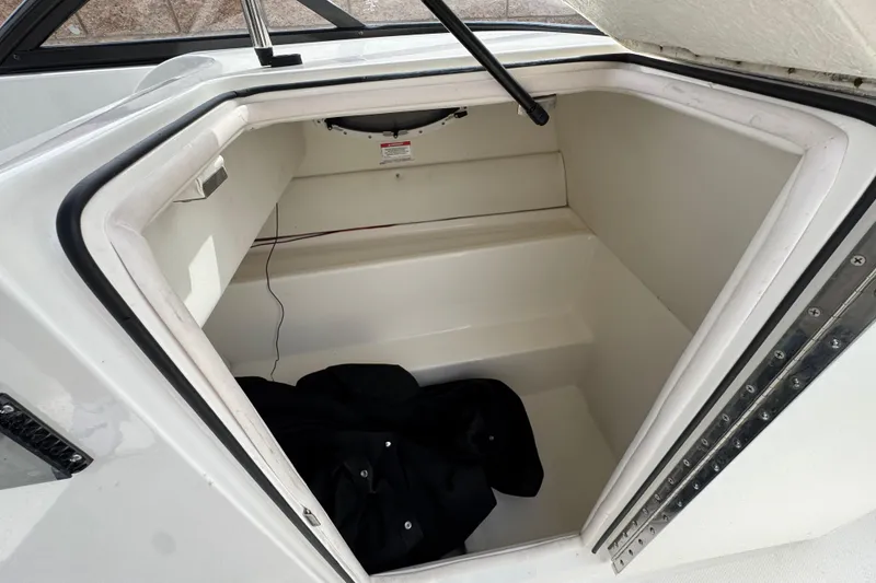 Slide: The Image of 2019 Bayliner VR6 Bowrider I/O storage compartment with open hatch and black cover inside. - 30