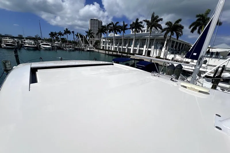 Slide: The Image of 2021 Regal 38 XO yacht docked at a marina with palm trees and buildings. - 11