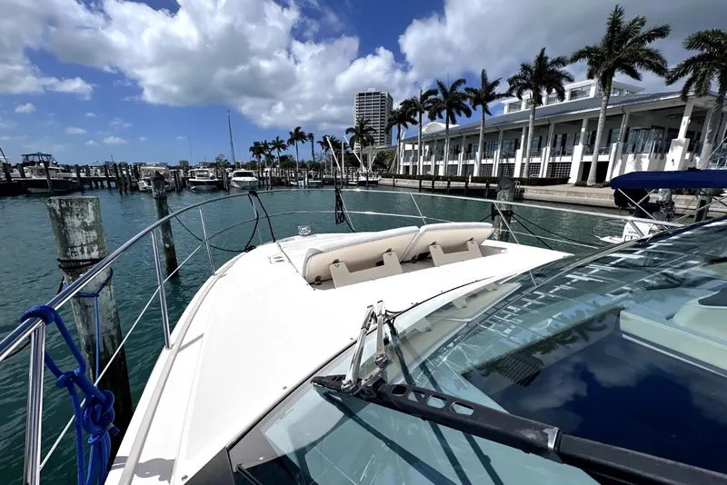 Slide: The Image of 2021 Regal 38 XO yacht docked at marina with palm trees and blue sky. - 17