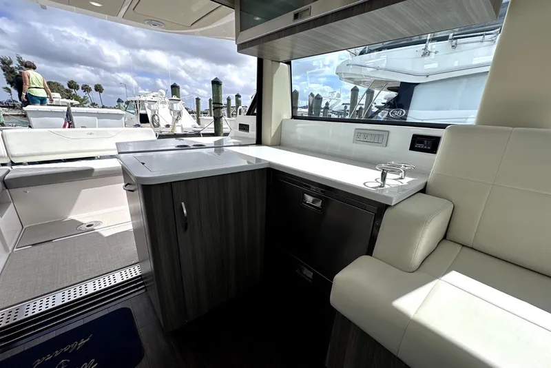 Slide: The Image of Interior view of 2021 Regal 38 XO yacht with modern seating and kitchenette. - 22