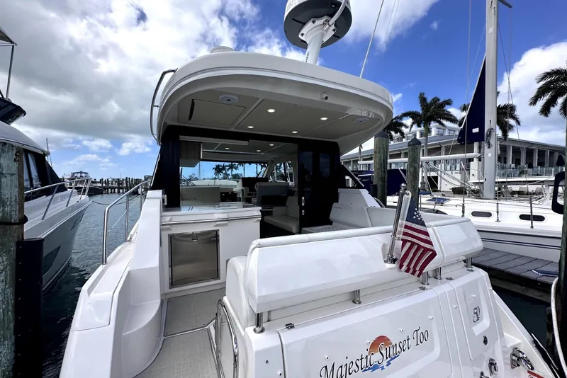 Slide: The Image of 2021 Regal 38 XO yacht docked, featuring spacious deck and American flag. - 27