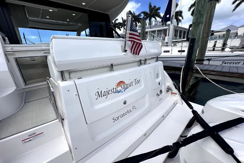 Slide: The Image of 2021 Regal 38 XO yacht docked in Sarasota, Florida, with American flag displayed. - 30