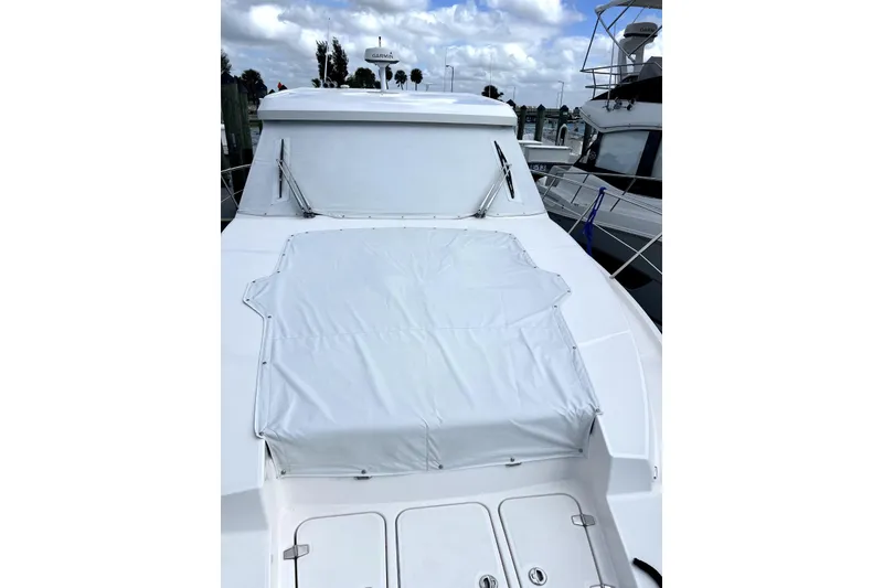 Slide: The Image of 2021 Regal 38 XO yacht with covered deck, docked under cloudy sky. - 4