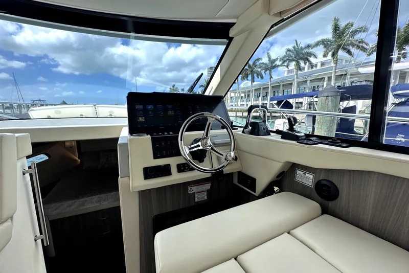 Slide: The Image of Interior view of 2021 Regal 38 XO yacht cockpit with steering wheel and navigation controls. - 44