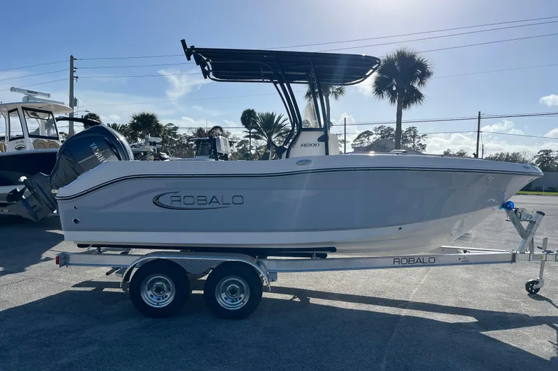 Slide: The Image of 2026 Robalo R200 Center Console boat on trailer, parked outdoors under clear sky. - 5