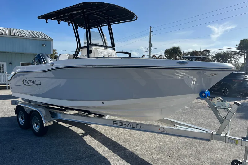 Slide: The Image of 2026 Robalo R200 Center Console boat on trailer, parked outdoors under clear sky. - 6