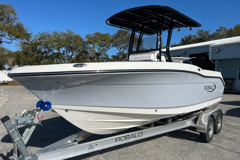 Slide: The Image of 2026 Robalo R200 Center Console boat on trailer, parked outdoors. - 8