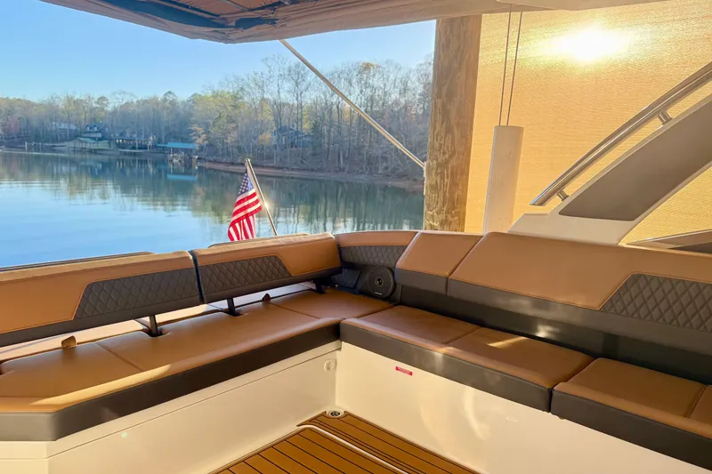 Slide: The Image of Luxurious seating on 2025 Cobalt R33 boat with scenic lake view and American flag. - 10
