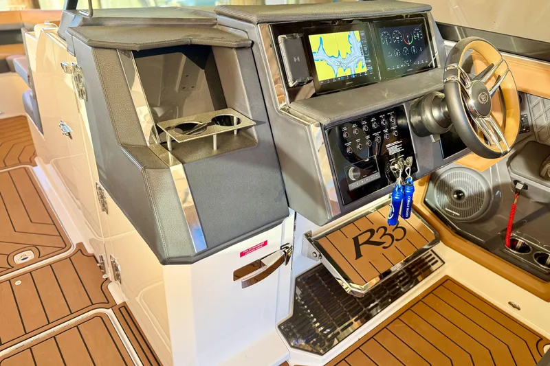 Slide: The Image of 2025 Cobalt R33 boat dashboard with navigation screens and steering wheel. - 17
