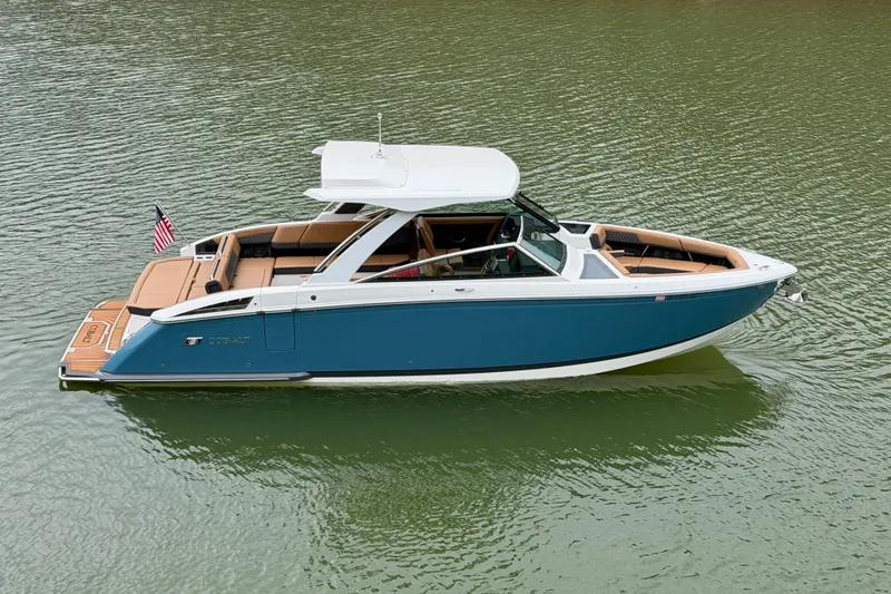 Slide: The Image of 2025 Cobalt R33 boat on water, featuring sleek design and luxurious seating. - 2
