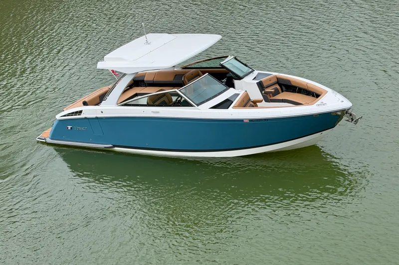 Slide: The Image of 2025 Cobalt R33 boat with sleek design, blue hull, and spacious seating on calm water. - 3